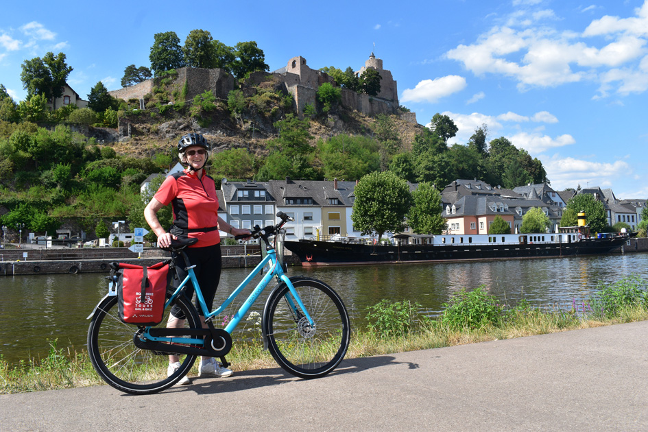 Guest posing with a bike at the river Saar in Saarburg