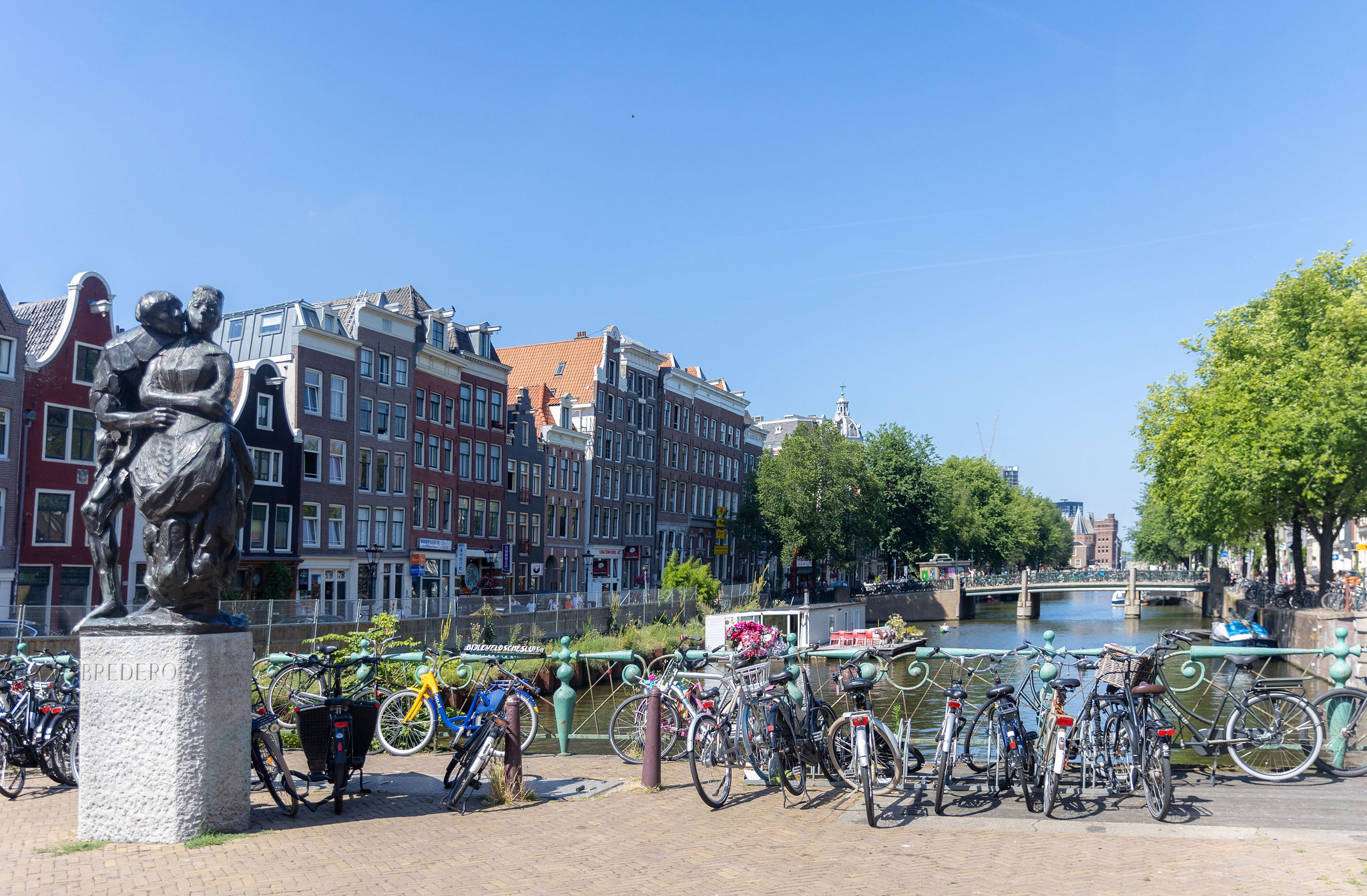 Statue next to a channel and buildings in Amsterdam