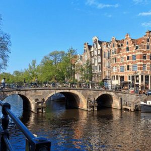 Canals of Amsterdam with a bridge, a boat an the typical canal houses